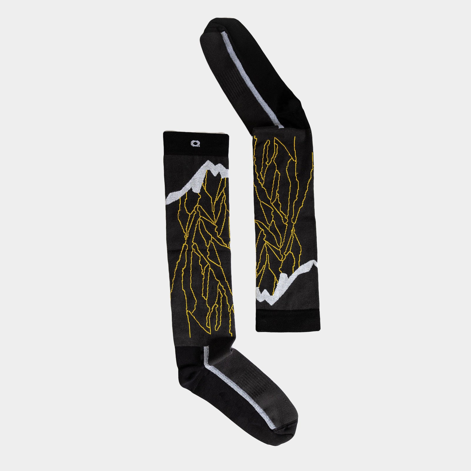 A pair of black knee-high socks with yellow lightning bolt patterns and white accents, laid flat on a light gray background.